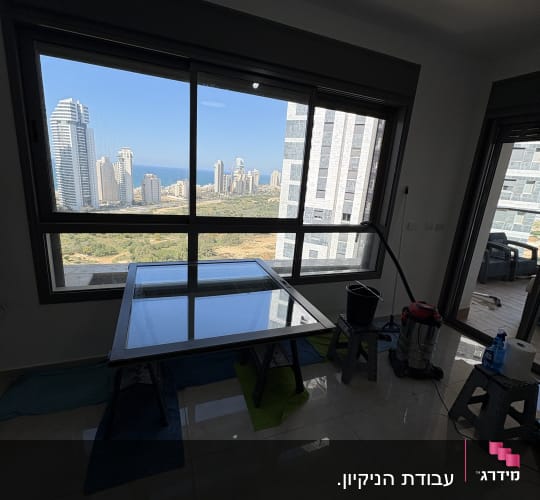 חלון גדול עם נוף עירוני, דלי ושואב אבק